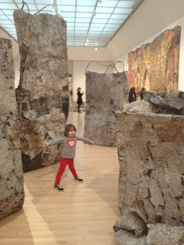 a little girl standing in a museum