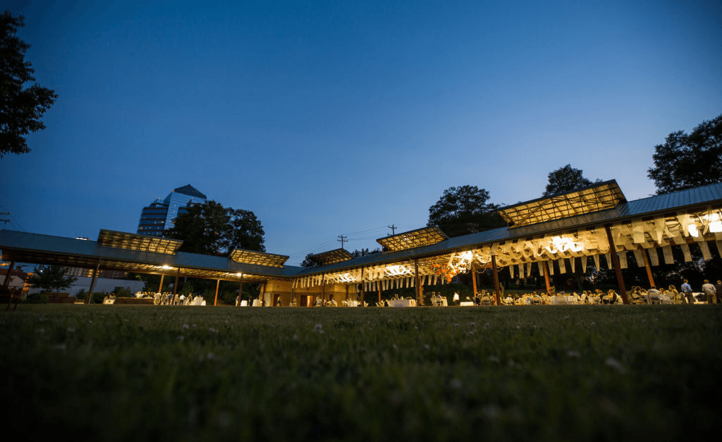 a view of a building at night from the grass