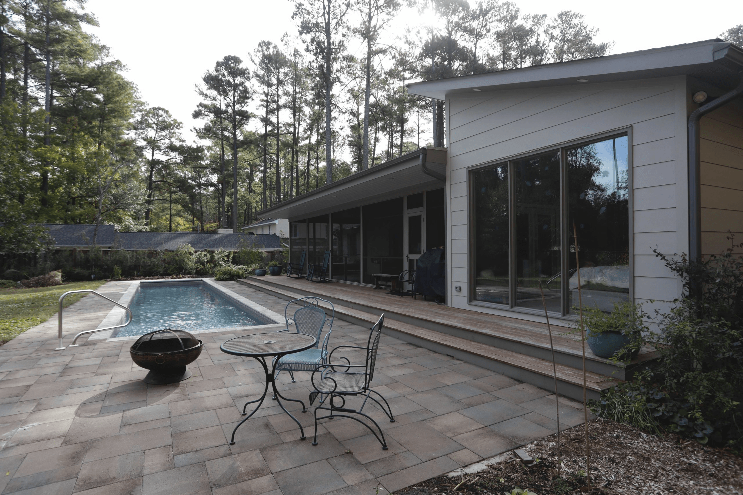 a patio with a table and chairs next to a pool